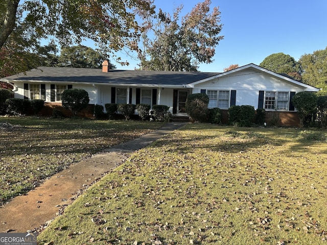 ranch-style house featuring a front lawn and a chimney