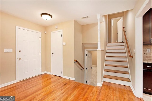 entryway with visible vents, light wood-type flooring, and baseboards