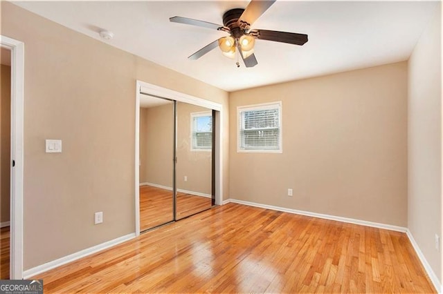 unfurnished bedroom with light wood finished floors, ceiling fan, a closet, and baseboards