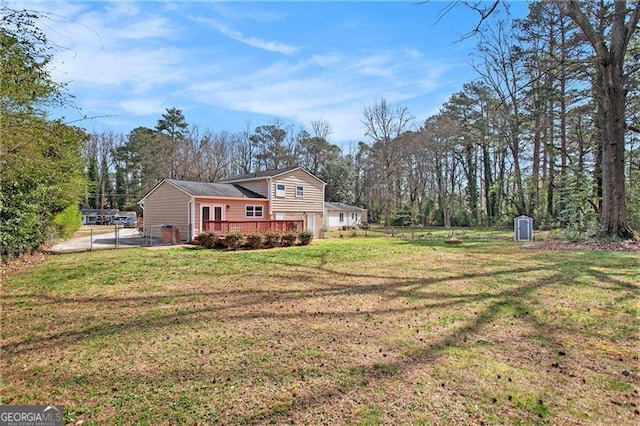exterior space featuring a lawn, a deck, and fence