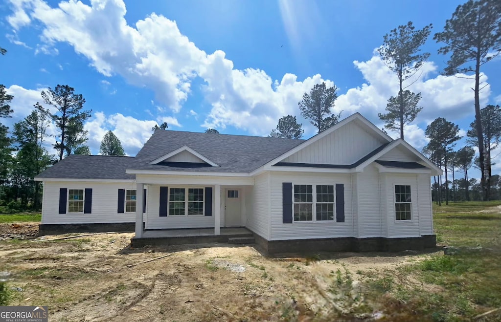 view of front of home with a shingled roof and a porch