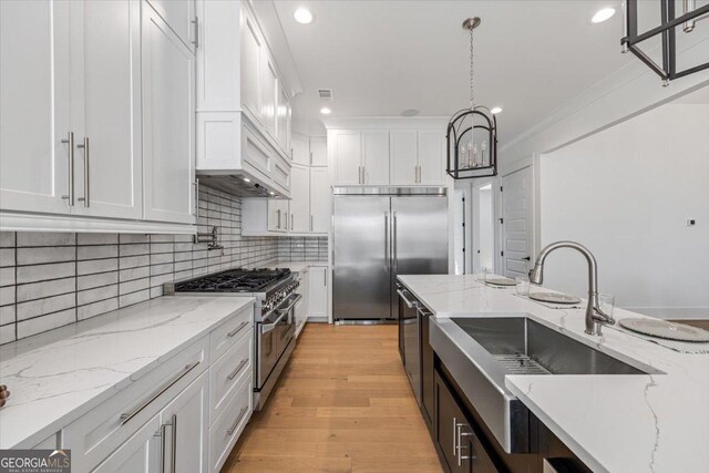 104 Piedmont Cir, Forsyth, GA 31029 - kitchen featuring premium appliances, white cabinets, decorative backsplash, recessed lighting, and decorative light fixtures
