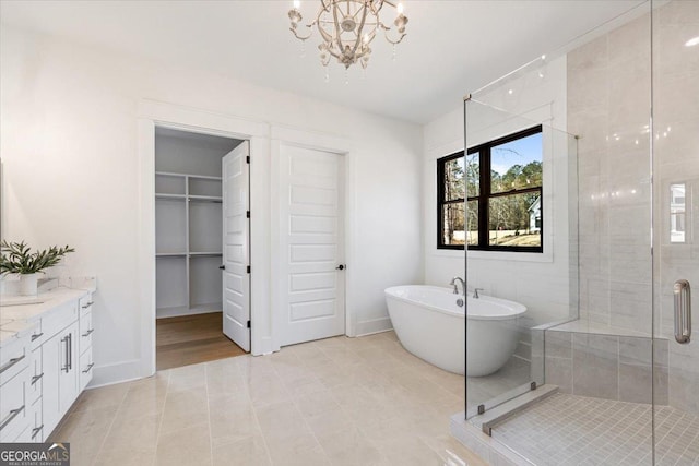 104 Piedmont Cir, Forsyth, GA 31029 - full bath with a stall shower, a freestanding tub, a chandelier, vanity, and a walk in closet