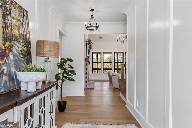 104 Piedmont Cir, Forsyth, GA 31029 - corridor featuring a chandelier, wood finished floors, baseboards, and ornamental molding