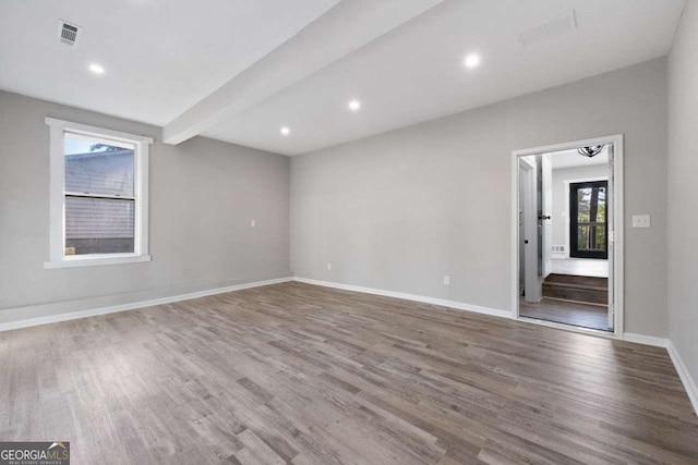 2014 Poplar Rdg, Lawrenceville, GA 30044 - empty room with visible vents, baseboards, beam ceiling, and wood finished floors