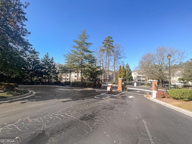 1250 Parkwood Cir SE Unit 300/230, Atlanta, GA 30339 - view of asphalt street featuring street lighting, curbs, a gated entry, and a gate