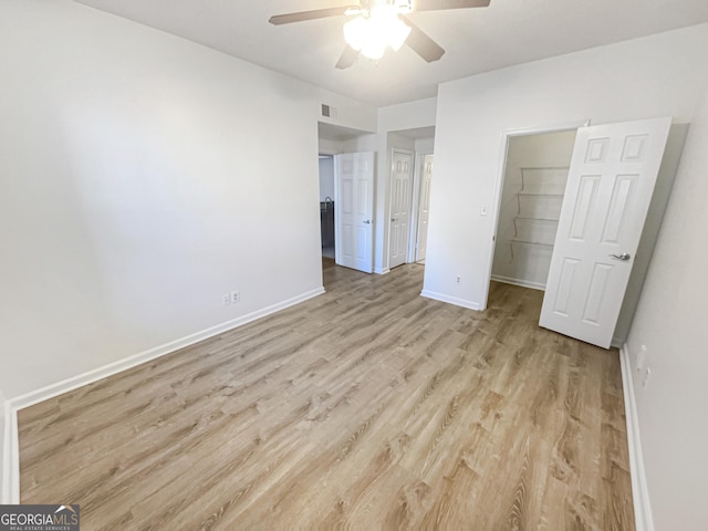 1250 Parkwood Cir SE Unit 300/230, Atlanta, GA 30339 - unfurnished bedroom with light wood-style floors, baseboards, a spacious closet, a closet, and a ceiling fan