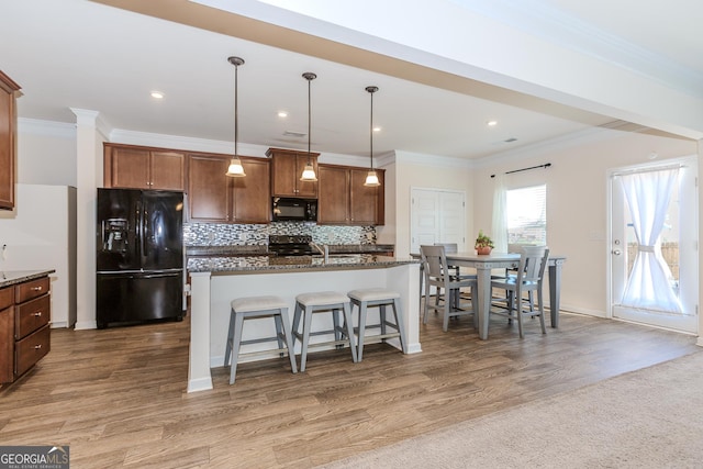 3391 Meadow Grass Dr, Dacula, GA 30019 - kitchen with black appliances, a kitchen breakfast bar, ornamental molding, backsplash, and hanging light fixtures
