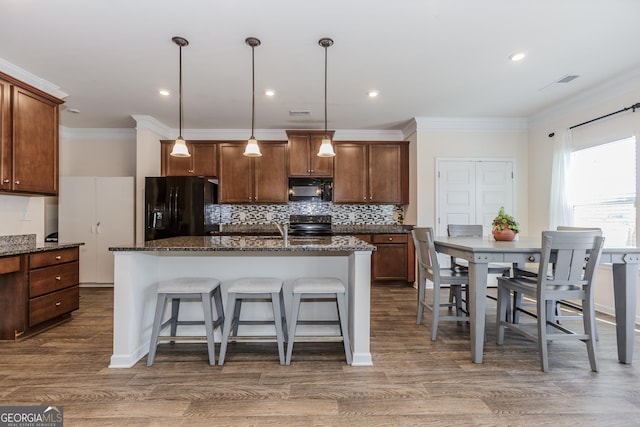 3391 Meadow Grass Dr, Dacula, GA 30019 - kitchen with black appliances, ornamental molding, tasteful backsplash, a breakfast bar area, and dark stone counters
