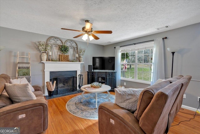 81 Summer Creek Dr, Dallas, GA 30157 - living room with a ceiling fan, wood finished floors, visible vents, a fireplace, and a textured ceiling