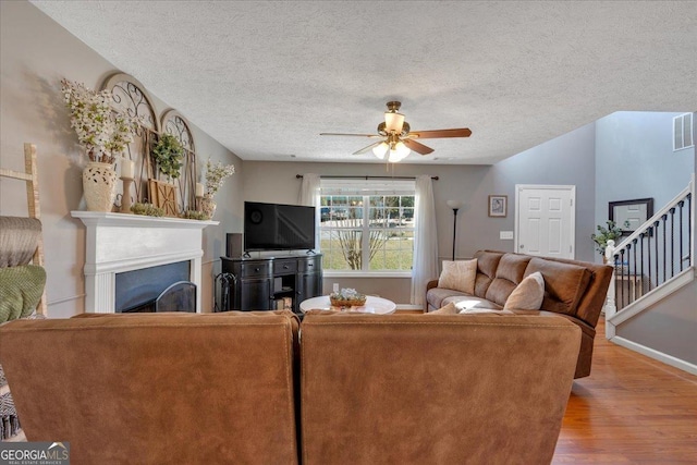 81 Summer Creek Dr, Dallas, GA 30157 - living area featuring wood finished floors, visible vents, a fireplace, ceiling fan, and a textured ceiling