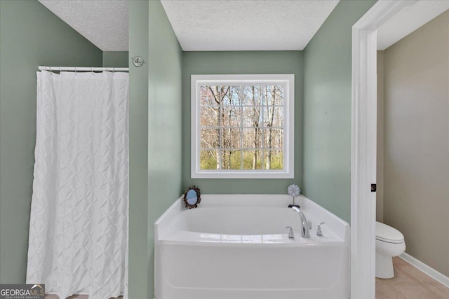 81 Summer Creek Dr, Dallas, GA 30157 - bathroom featuring a garden tub, toilet, a textured ceiling, tile patterned flooring, and baseboards