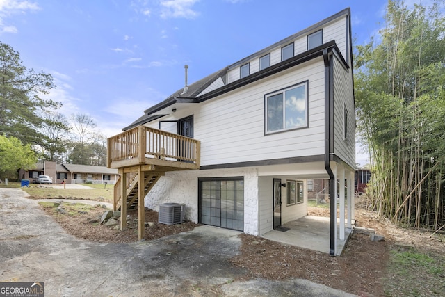 rear view of house featuring stairs, central air condition unit, a deck, and a patio area