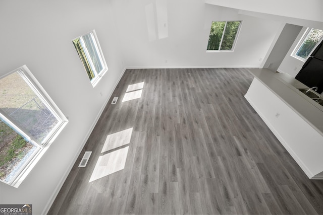 unfurnished living room with baseboards and wood finished floors