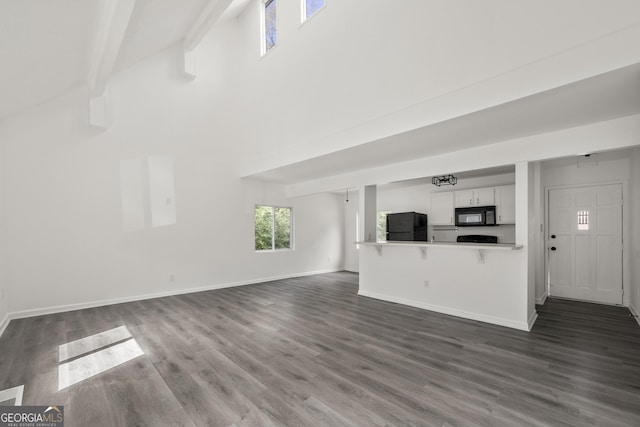 unfurnished living room with dark wood finished floors and baseboards