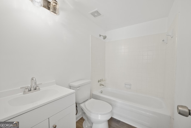 bathroom featuring toilet, vanity, shower / bathing tub combination, wood finished floors, and visible vents