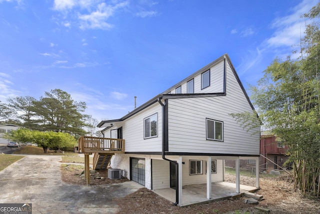 view of side of property with a patio, stairs, central air condition unit, and a wooden deck