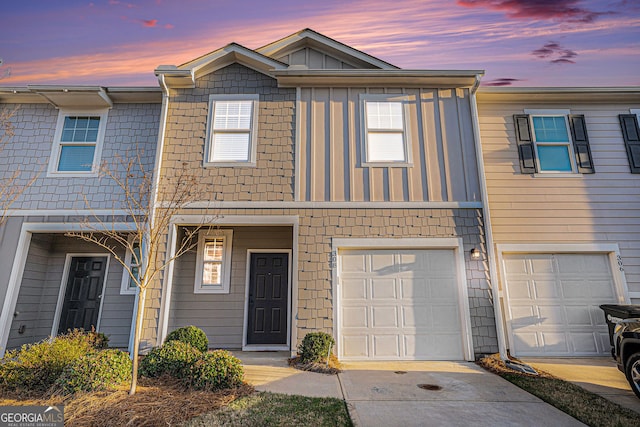 multi unit property with concrete driveway, board and batten siding, and an attached garage