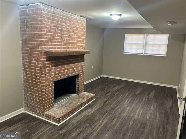 unfurnished living room featuring baseboards, wood finished floors, and a fireplace