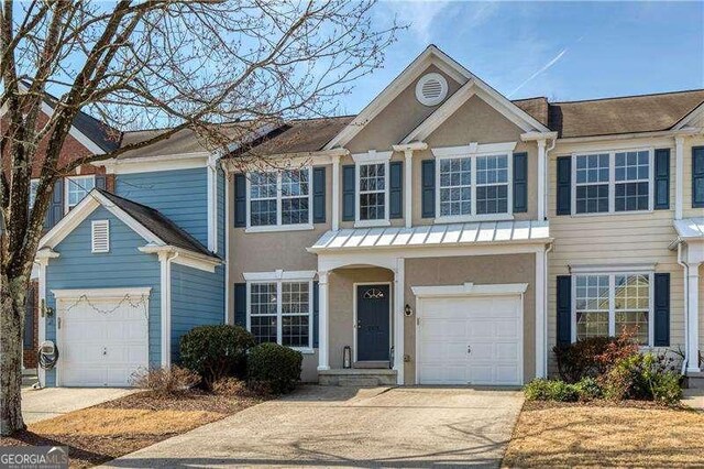 view of front of property featuring an attached garage, driveway, and stucco siding