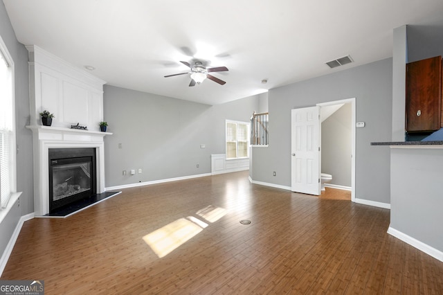 3258 Welmingham Dr SW, Atlanta, GA 30331 - unfurnished living room with a glass covered fireplace, visible vents, wood finished floors, and a ceiling fan