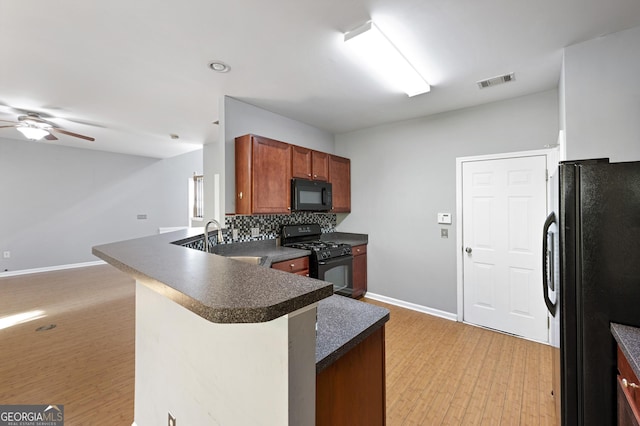 3258 Welmingham Dr SW, Atlanta, GA 30331 - kitchen with black appliances, a ceiling fan, visible vents, a peninsula, and dark countertops