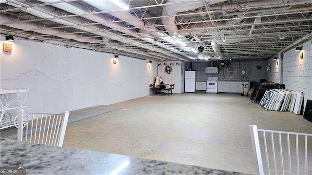 below grade area featuring freestanding refrigerator
