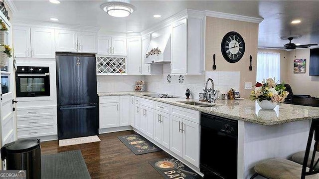 kitchen featuring white cabinetry, black appliances, custom range hood, and a sink