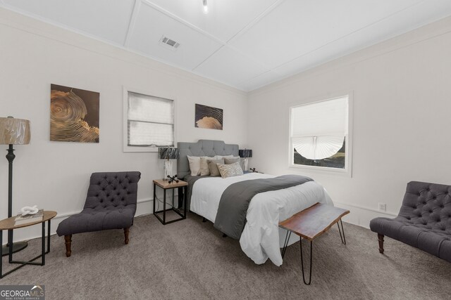 carpeted bedroom featuring visible vents, multiple windows, and crown molding