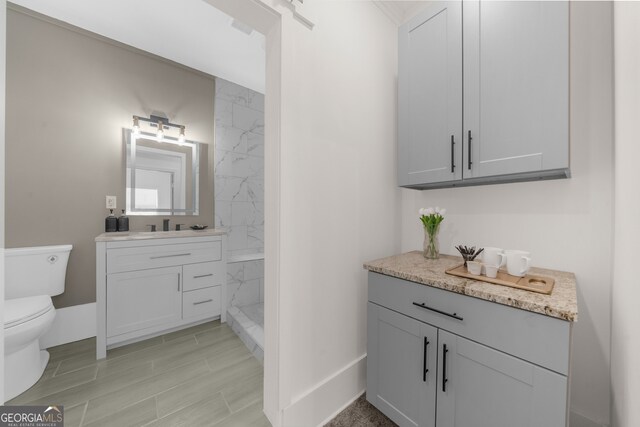 bathroom with walk in shower, wood tiled floor, vanity, and toilet