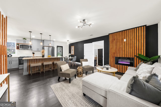 living room featuring recessed lighting, an inviting chandelier, a glass covered fireplace, visible vents, and dark wood-type flooring