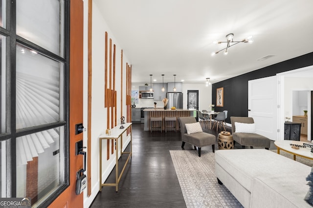 living room with dark wood-style floors and visible vents