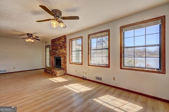 unfurnished living room featuring visible vents, baseboards, and light wood-style floors