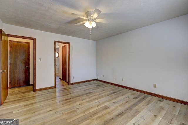 unfurnished room with baseboards, a textured ceiling, ceiling fan, and light wood finished floors