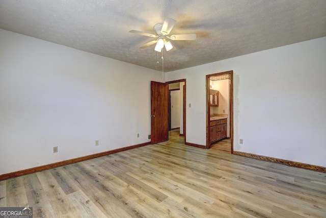 interior space with a textured ceiling, baseboards, light wood finished floors, and ceiling fan