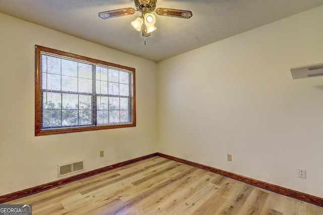 unfurnished room with visible vents, light wood-style flooring, and baseboards