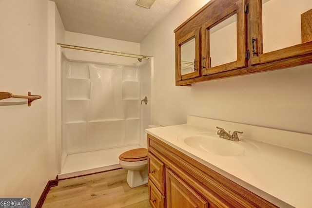 full bath with wood finished floors, toilet, a shower, and a textured ceiling