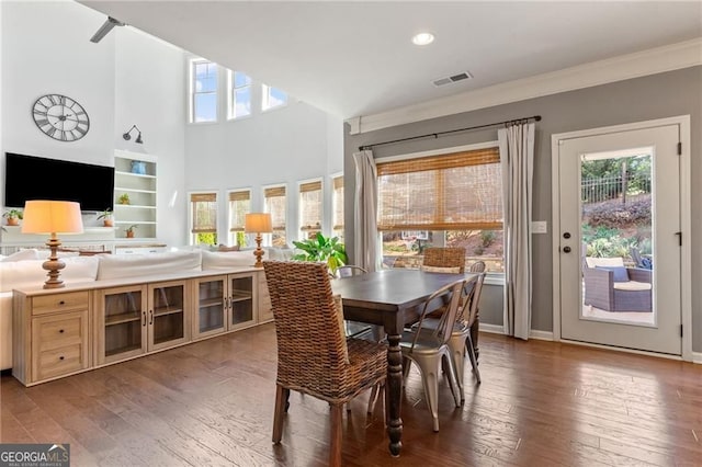 dining room with plenty of natural light, hardwood / wood-style flooring, visible vents, and crown molding