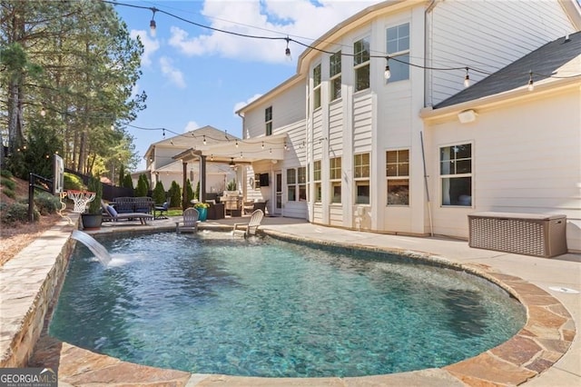 rear view of property with a patio area and a fenced in pool