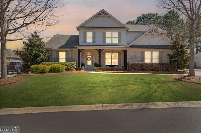 craftsman house with brick siding and a lawn