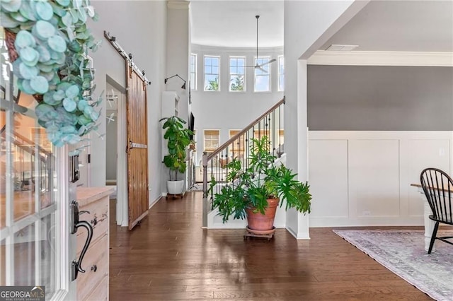 9085 Maple Run Trl, Gainesville, GA 30506 - foyer entrance featuring a barn door, crown molding, dark wood-style flooring, stairs, and a decorative wall