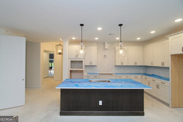 2044 Ripple Park Bnd, Canton, GA 30114 - kitchen with an island with sink, backsplash, white cabinetry, recessed lighting, and hanging light fixtures