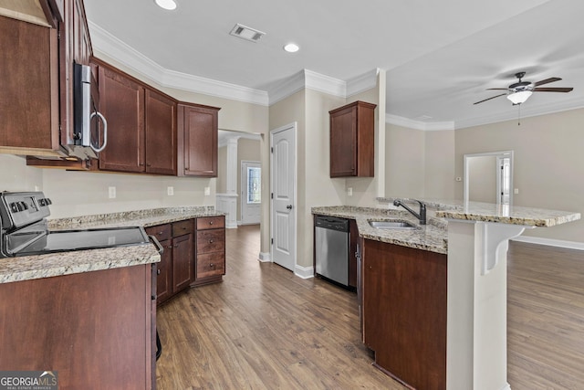 kitchen featuring appliances with stainless steel finishes, a sink, a peninsula, dark wood-type flooring, and visible vents