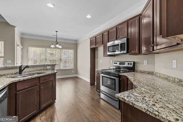 kitchen featuring ornamental molding, dark wood-style flooring, light stone countertops, a sink, and stainless steel appliances
