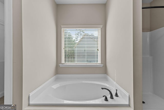 bathroom featuring a stall shower and a garden tub