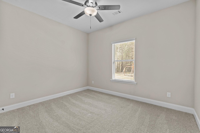 carpeted spare room featuring a ceiling fan, baseboards, and visible vents