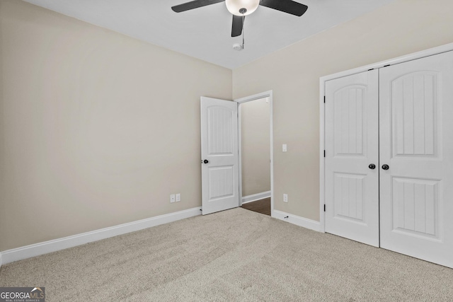 unfurnished bedroom with carpet floors, baseboards, ceiling fan, and a closet