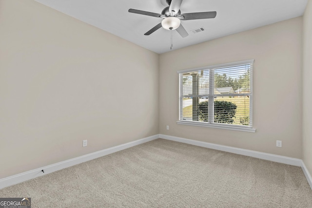 carpeted spare room featuring a ceiling fan, baseboards, and visible vents