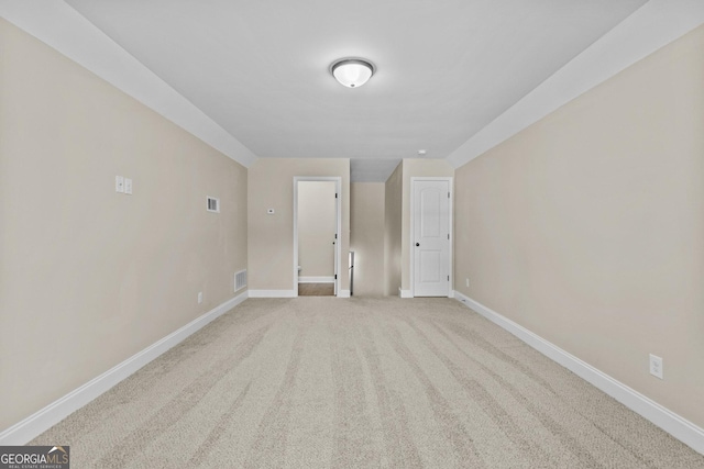 unfurnished room with baseboards, light carpet, and visible vents