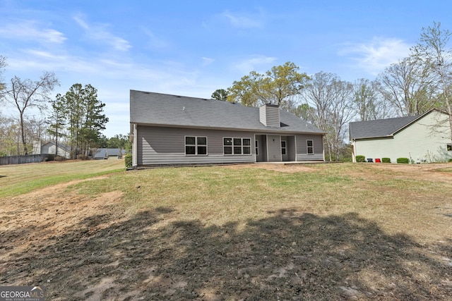 rear view of property featuring a lawn